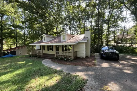 Cape Cod cottage with a covered front porch on a wooded lot in North Georgia
