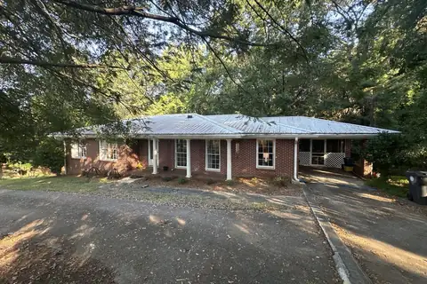 Brick ranch with a metal roof and columned front porch in North Georgia
